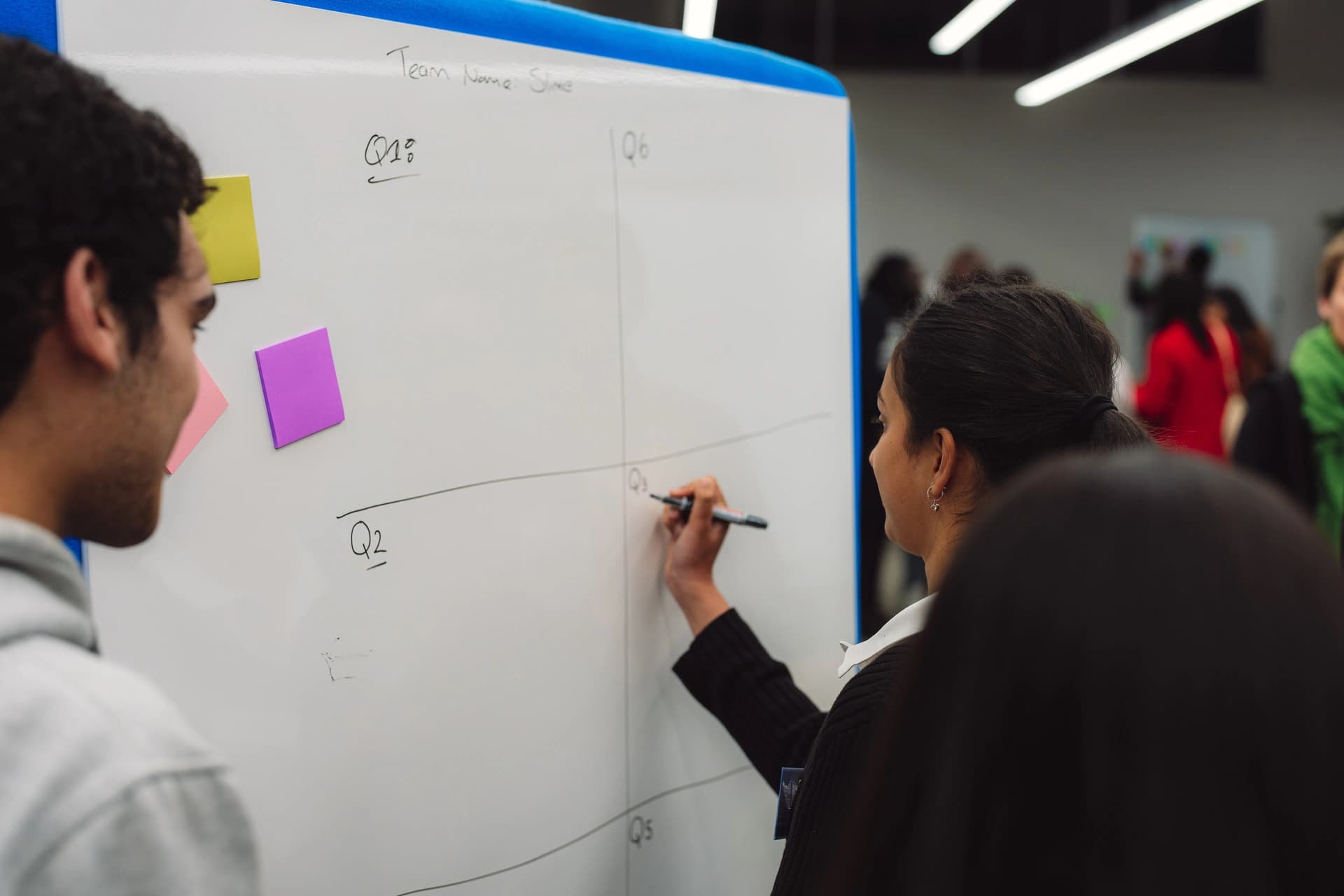 Students working through questions together on a whiteboard during a workshop